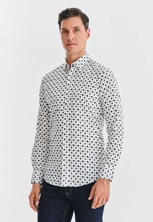 Biała koszula na guziki z granatowym wzorem w kształcie kół. Wąski fason z długimi rękawami i standardowym kołnierzykiem. Styl casual.