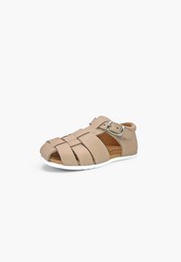 Sandale beige pour tout-petit avec talon fermé, bout ouvert, brides en cuir et boucle argentée sur fond blanc.