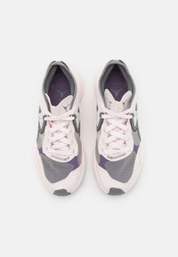 Chaussures de sport rose clair avec des accents gris, violets et à motifs. Dotées d'un bout arrondi, d'un design à lacets et de matériaux texturés.