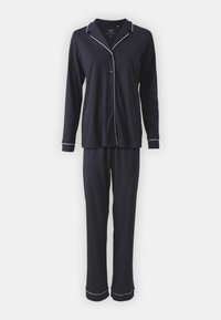 Mörkblå pyjamasset i mjukt material. Långärmad skjorta med vita pipade kanter och knappstängning fram. Matchande byxor med manchetter.