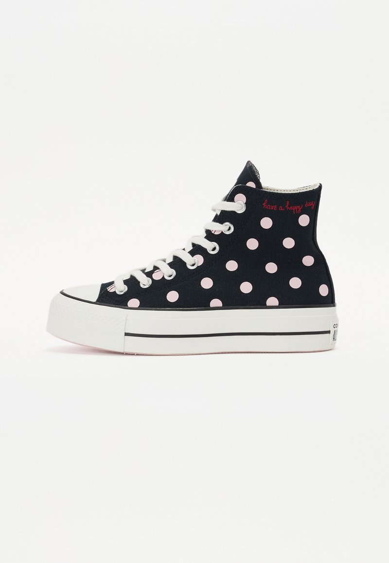 Svarta höga sneakers i canvas med rosa prickar, vita snören och en tjock vit sula med en svart rand. Texten säger "ha en glad dag."