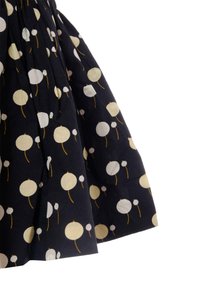 Gonna in tessuto blu navy con un motivo di cerchi bianchi e crema con steli gialli. Il tessuto presenta un design testurizzato e leggermente plissettato.