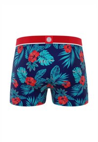 Maillot de bain bleu marine avec ceinture rouge, orné de fleurs d'hibiscus rouges vibrantes et de feuilles turquoise dans un motif tropical.