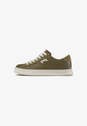 Low-top olijfgroene sneaker met witte veters, lichtbeige zool en suède hielstuk, gezien van opzij op een witte achtergrond.