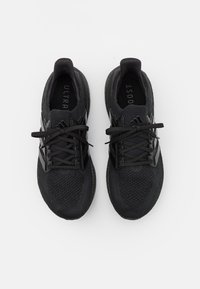 Pár černých běžeckých bot Adidas Ultraboost s pleteným svrškem a tkaničkami, zobrazený z výšky na bílém pozadí.