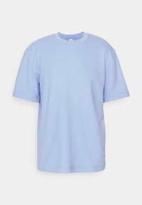 Lichtblauw t-shirt met korte mouwen van zachte katoenstof, met een ronde halslijn en een relaxte pasvorm. Eenvoudige, effen kleur zonder patronen.