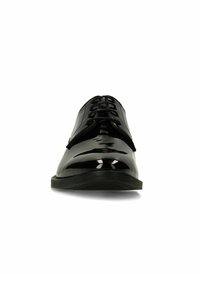 Glanzende zwarte veterlosse nette schoen met een gladde afwerking en licht spitse neus, gezien van voren op een witte achtergrond.