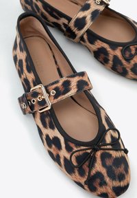 Baleriny w print leopardzi z czarnym paskiem z złotą klamrą, okrągły czubek oraz delikatny akcent w formie kokardki. Miękka podszewka.