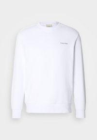 Sudadera blanca hecha de tela suave, con cuello redondo, mangas largas y un pequeño logo de Calvin Klein en el lado izquierdo del pecho.