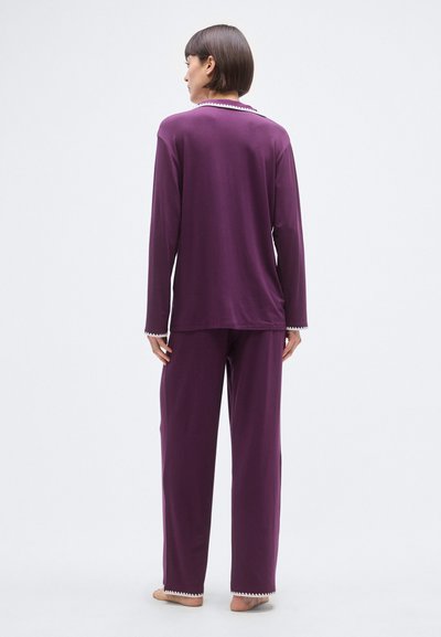 Vijolična majica z dolgimi rokavi in ujemajoče hlače iz mehke tkanine, z reliefnim robom na izrezu in manšetah.
