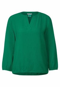 Blusa verde in tessuto testurizzato, con scollatura a V, maniche lunghe e vestibilità rilassata. Motivo leggermente sgualcito su tutta la superficie.