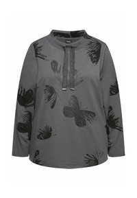 Maglia grigia a maniche lunghe con stampa di farfalla nera, scollatura rotonda e due stringhe decorative con punte in metallo.