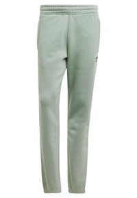 Ljusgröna sweatpants gjorda av mjukt material, med elastisk midja, avsmalnande ben och en liten logodetalj på vänster höft.