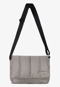 Grey padded messenger bag with a black adjustable strap, featuring stitched sections and a logo patch on the front. Smooth texture.