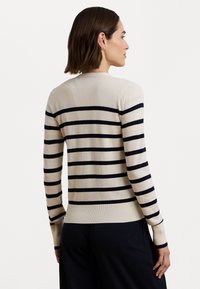 Beige striped sweater with navy stripes, long sleeves, and a fitted design. Soft texture, round neck, and ribbed cuffs and hem.