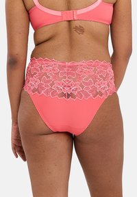 Koraal kleurige onderbroek met een hoge taille en een bloemige kantafwerking. Gladdde stof met een gegolfde rand en een subtiele textuur.