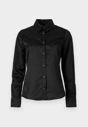 Čierna saténová košeľa s predným zapínaním na gombíky, špicatým golierom a yoke v západnom štýle so zúbkovanými dvoma vreckami na hrudi. Dlhé rukávy s manžetami.