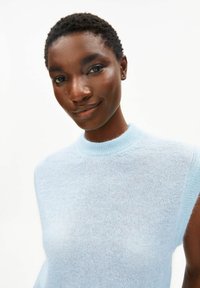 Lichtblauwe mouwloze trui met een hoge hals, gemaakt van een zacht, gebreid materiaal met een gladde textuur en subtiele glans.