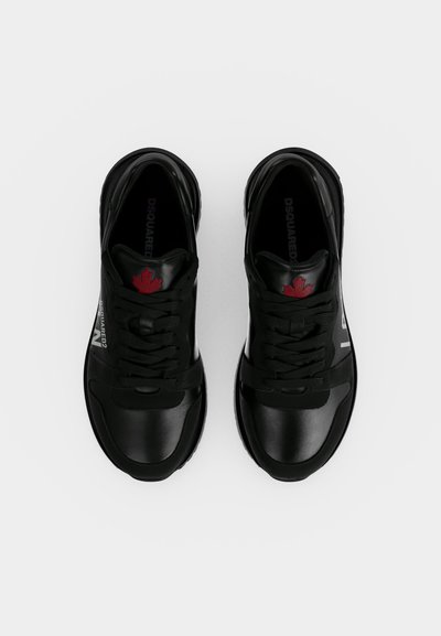 Paire de baskets en cuir noir avec lacets noirs, feuille d'érable rouge sur la languette et logo blanc de la marque sur le côté, vue de dessus.