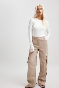 Beige hoge taille cargobroek met zijzakken en wijde pijpen, gecombineerd met een aansluitend wit longsleeve shirt. Gladde stoftextuur.
