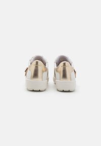 Sneakers bianchi da uomo con accenti metallici dorati sul tallone, con una texture liscia e una punta arrotondata.