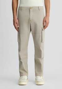 Beige cargo nadrág, könnyű anyagból készült, oldalsó zsebekkel, gombos záródással és egyenes szárajakkal.