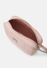 Růžová prošívaná kabelka se stříbrnými detaily, zipovým zapínáním a řetízkem. Interiér má jednoduchou podšívku s přihrádkou na karty.