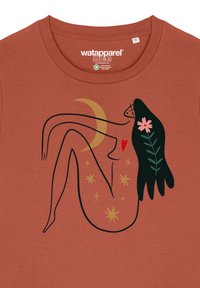 Roodachtige t-shirt met een lijntekening van een figuur met een halve maan, harten, bloemen en sterren in zwarte en gouden accenten.