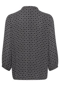 Langärmlige, navyblaue Bluse mit einem geometrischen cremefarbenen Muster. Sie hat einen minimalistischen Kragen und abgerundete Manschetten und besteht aus leichtem Stoff.