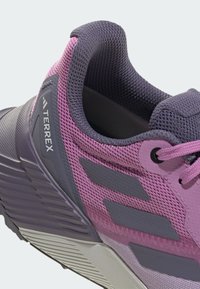 Paarse en grijze sport schoenen met een bovenwerk van gaas, gestructureerde accenten, contrasterende strepen, gevoerde kraag en stevige rubberen zool.