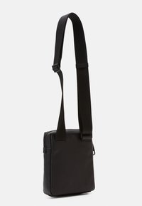 Borsa a tracolla nera in pelle texturizzata con chiusura a zip. Dotata di una tracolla larga regolabile e di una forma rettangolare compatta.