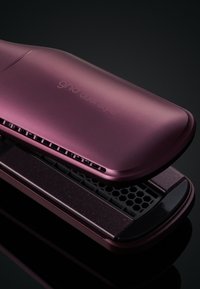 Outil de coiffure violet au fini mate élégant ; présente une surface texturée avec un design en nid d'abeille et un logo gravé sur le couvercle.