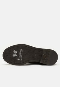 Black shoe sole with textured surface, featuring embossed logo and size indication. Durable material with subtle wear patterns visible.
