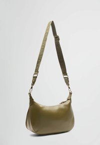 Olijfgroene leren handtas met een ronde vorm, voorzien van een gestructureerde schouderband en goudkleurige details. Ritssluiting aan de bovenkant.