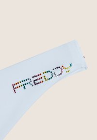 Valkoinen puuvillakangas, jossa on sileä pinta, ja jossa on monivärisiä timantteja sanat "FREDDY". Suunnitelmassa on kiiltävä pinta ja pyöristetyt reunat.