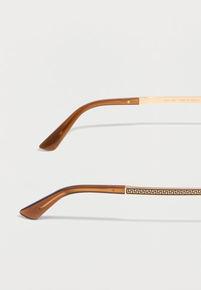 Καφέ και χρυσά μπράτσα γυαλιών με σχέδιο ελληνικού κλειδιού στη μία πλευρά και λείες καφέ πλαστικές άκρες και στις δύο πλευρές.