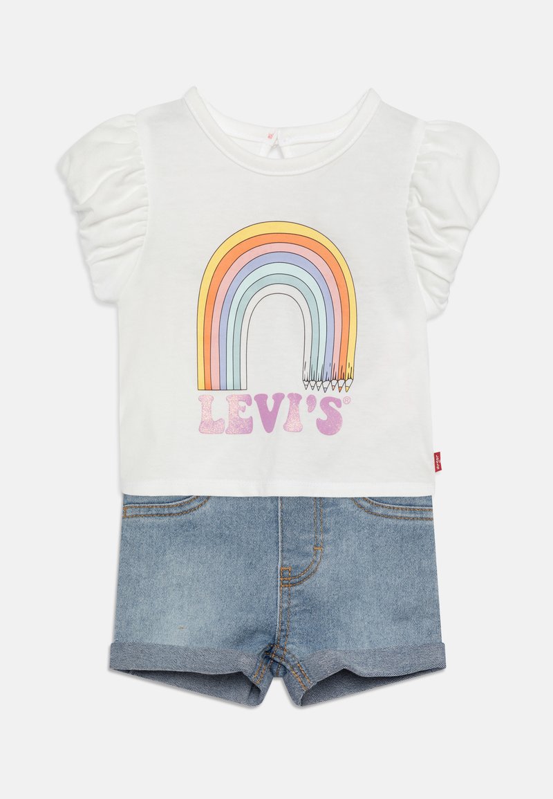 Fehér, rövid ujjú póló szivárvány grafikával és "LEVI'S" felirattal, világoskék farmer rövidnadrággal, amelyen felgöngyölt szárak és zsebek találhatók.