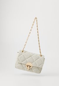 Quiltet grå stof taske med en guld kædestropp, som har en rund guld lukning på forsiden. Kompakt rektangulær form.