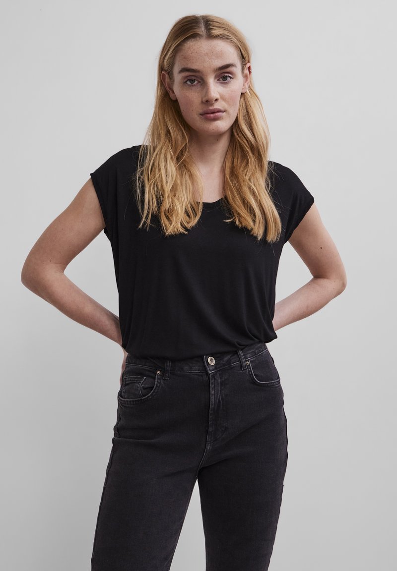 Svart kortermet topp med rund hals, laget av et glatt stoff, kombinert med høyt liv mørk denim jeans med frontlommer.