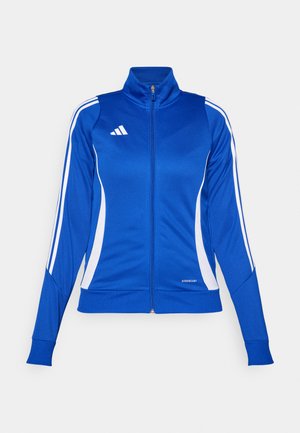 Modra športna zadrge jakna z belimi stranskimi paneli in tremi črtami na rokavih. Material je gladek in rahlo elastičen. Ima visok ovratnik.