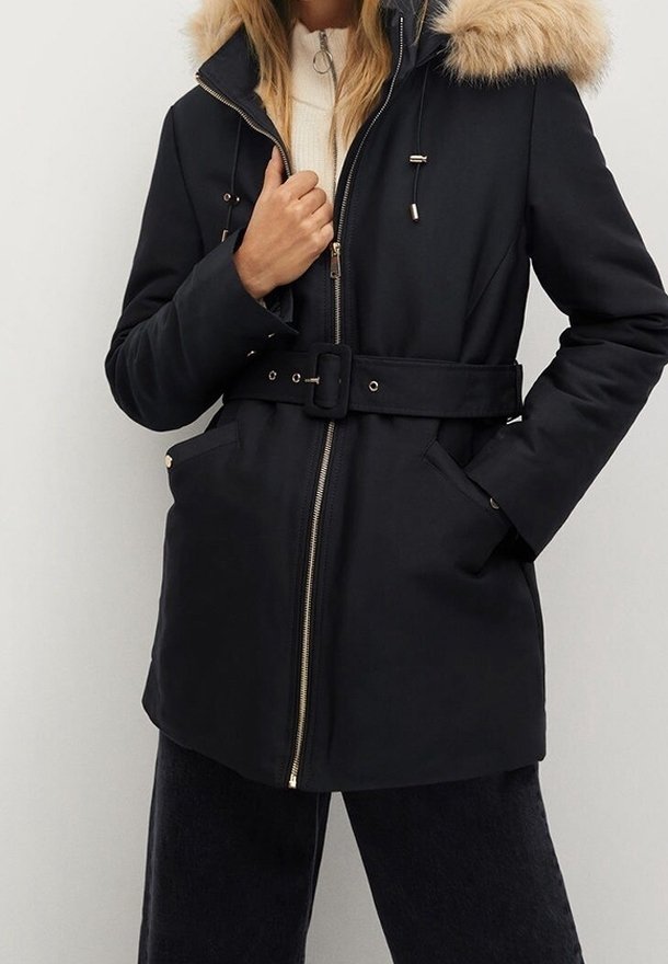 Schwarze Parka mit einer Kapuze aus Fellschnur, Gürtel in der Taille, Reißverschluss und seitlichen Taschen. Glatte Textur mit goldenen Hardware-Akzenten.