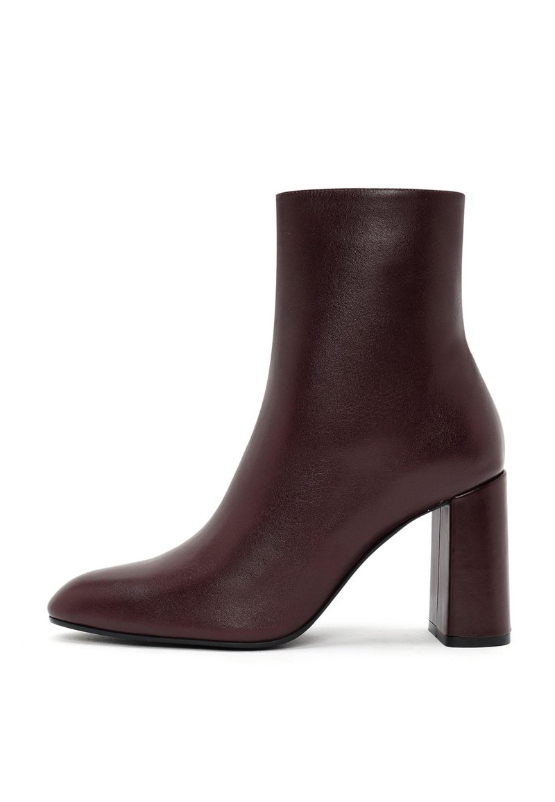 Stivaletto borgogna realizzato in pelle liscia con punta affusolata e tacco quadrato, caratterizzato da un design elegante e minimalista.