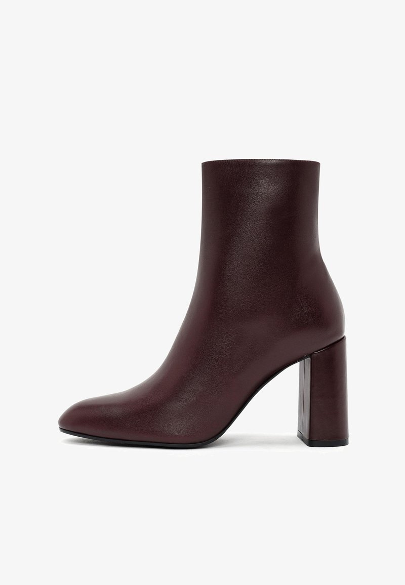 Stivaletto borgogna realizzato in pelle liscia con punta affusolata e tacco quadrato, caratterizzato da un design elegante e minimalista.