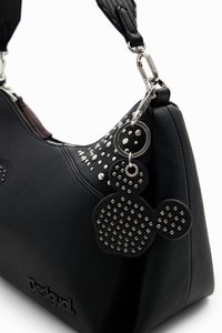 Black synthetic handbag with textured surface, studded accents, and a charm featuring a circular design. Zippered closure and a detachable strap.