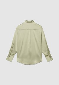 Hellbeige Satinbluse mit langen Ärmeln, Rückenfalte, geknöpften Manschetten und klassischem Kragen vor schlichter Hintergrund.