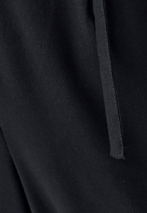 Čierna tkanina s hladkou, matnou textúrou; obsahuje rovný šev a zúženú šnúrku na sťahovanie. Detail zobrazuje šitie a zrno látky.