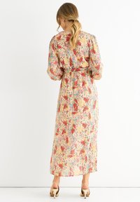Maxikleid aus leichtem Stoff mit einem mehrfarbigen Blumenmuster in den Farben Rot, Blau und Gelb. Lange Ärmel und taillierter Schnitt.