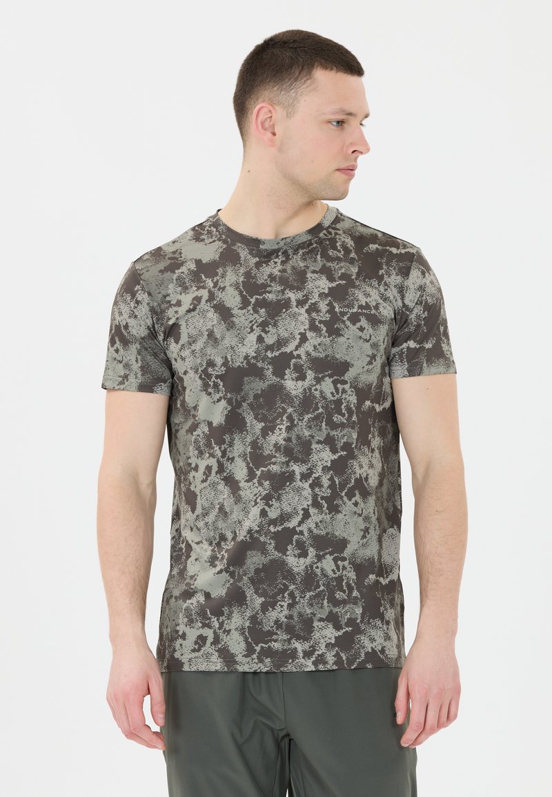 Kortärmad, rundhalsad t-shirt i en mörkgrå bas med ett texturerat, abstrakt mönster i grönt och svart. Tillverkad av lätt och stretchigt tyg.