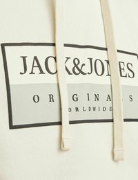 Krémová mikina s kapucí se čtvercovým logem v šedé a černé barvě s textem "JACK & JONES" a "ORIGINALS WORLDWIDE". Zahrnuje stahovací šňůrky.