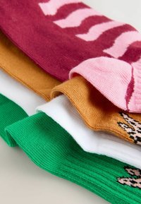 Fem par sokker i levende farver: maroon med rosa striber, guld, hvid, grøn og et rosa par med leopardprint. Blød strikket tekstur.